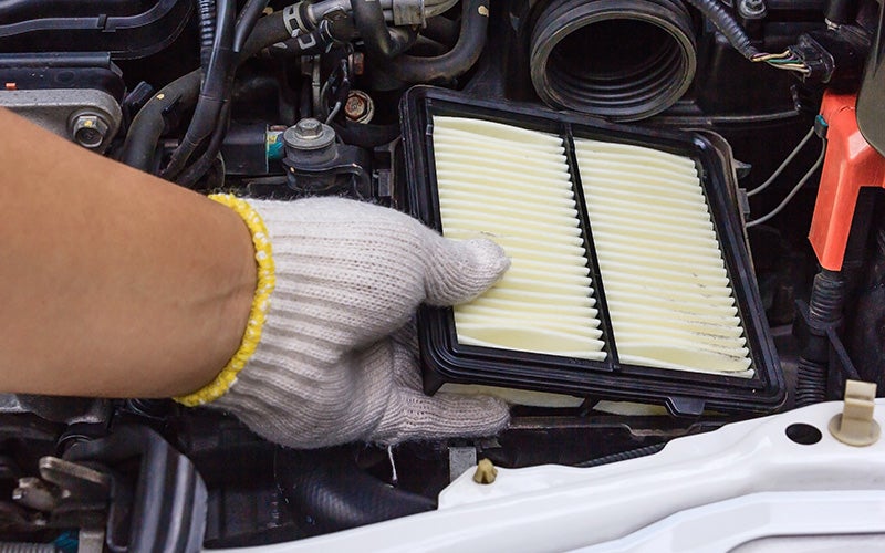 Close up of a clean air filter being put into car