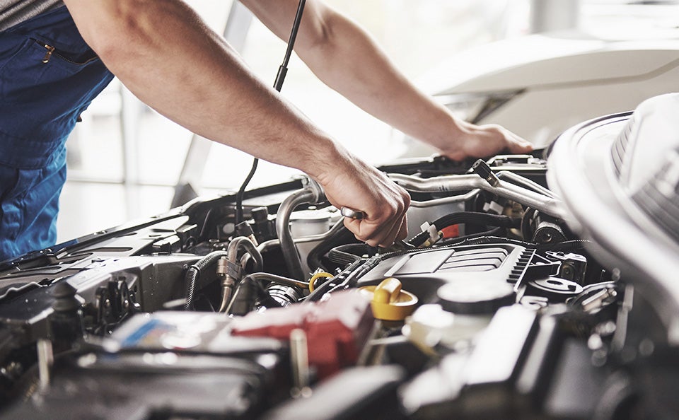Technician working on car engine